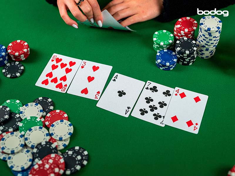 Pilha de fichas de cassino e royal flush baralho na mesa de poker verde